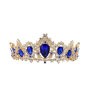 Detail of golden royal tiara with blue teardrop crystals and white rhinestones