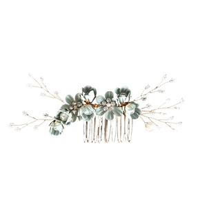Close-up of floral hair comb with fabric petals, pearls and crystals on a gold base