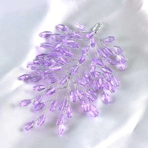 Detailed view of handmade purple crystal beads woven with silver wire for hair accessories