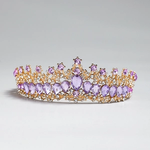 Dettaglio ravvicinato di una tiara barocca dorata con strass viola e filigrana