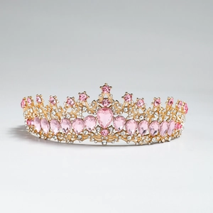 Dettaglio dell'elegante corona dorata con cristalli rosa a goccia e strass scintillanti