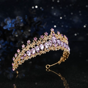 Dettaglio ravvicinato della corona da sposa dorata con cristalli viola e strass bianchi