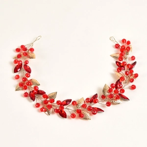 Détail d'une branche de feuilles dorées faite main avec perles de cristal rouge éclatant