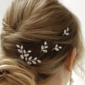 Bridal leaf hair pins set with silver metal base and clear marquise crystals on a gold bun