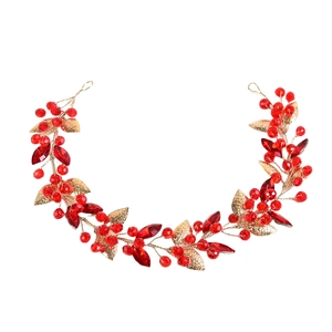 Détail d'un serre-tête doré orné de cristaux rouge rubis et de feuilles métalliques ciselées