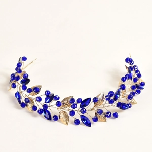 Détail du serre-tête feuilles dorées avec cristaux bleu roi pour mariages chic