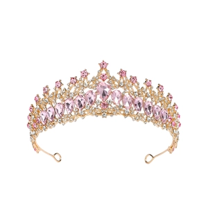 Dettaglio macro della tiara dorata con pietre preziose rosa a goccia e cristalli scintillanti