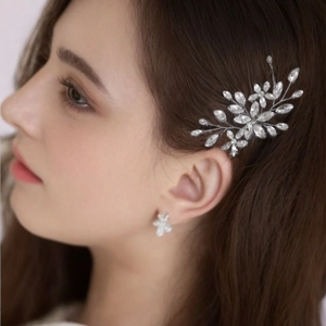 Silver bridal hair comb with flower crystal patterns worn by a model for weddings