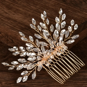 Close-up of handmade bridal hair comb with gold wires and sparkling crystal branches