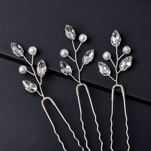Detail of silver U-shaped hair pins with crystals and pearls in leaf design