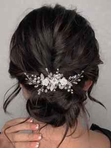 Vue détaillée de fleurs en résine blanche et perles de cristal sur un peigne de mariée