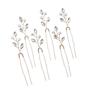 Detailed close-up of emerald style hair pins with pearls and leaf patterns