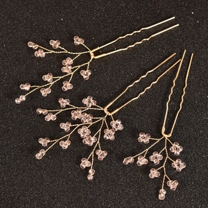 Détail de 3 épingles à cheveux dorées avec perles roses et design de branche tissée