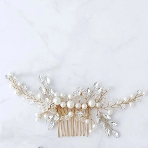 Silver bridal hair comb with handmade crystal beads and white pearls on marble background