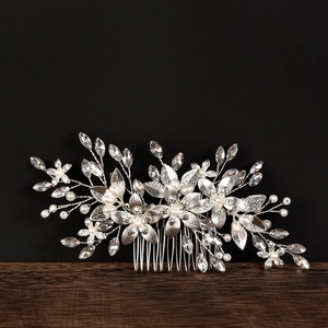 Detail of silver bridal hair comb featuring alloy flowers, faux pearls and clear rhinestones