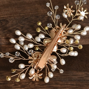 Close-up of bridal flower hair clip with pearls and crystals on vintage wood