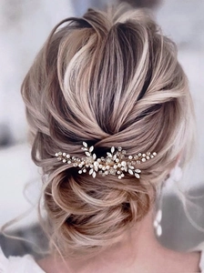 Detailed view of silver crystal bridal hair comb with pearls on elegant updo hairstyle