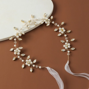 Close-up of bridal headpiece with white pearls, crystals, and gold wire floral details