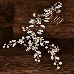 Vue macro d'un peigne de mariée avec pierres d'opale, cristaux et perles sur bois
