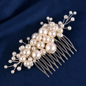 Close-up of handmade pearl bridal hair comb with silver wire weaving on velvet