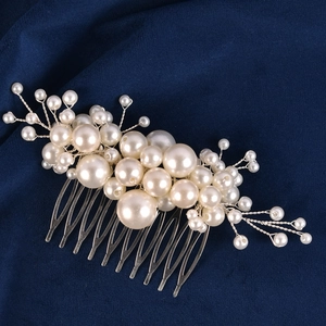 Macro view of handmade bridal hair comb with elegant white pearls and silver metal wire details