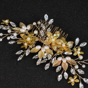 Macro shot of gold floral hair comb with pearls and rhinestones for weddings