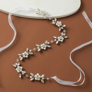 Detail of bridal sash with white pearls and sparkling rhinestones on ivory organza ribbon