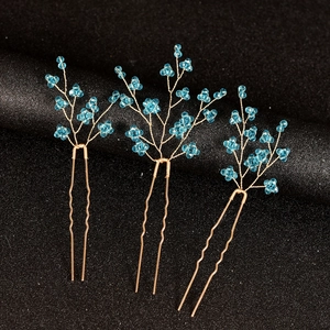 Vue détaillée de trois épingles à cheveux de mariée dorées avec perles bleues en U