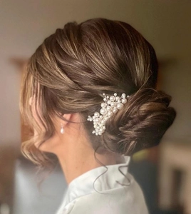Detail shot of a pearl bridal hair comb with elegant clusters and matching earring