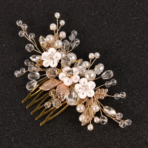 Détail de fleurs en céramique blanche et perles de cristal sur un peigne de mariée