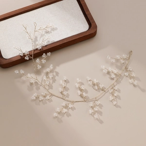 Détail de vigne de mariée faite main avec fil doré et perles de cristal sur fond neutre