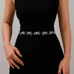 Close-up of bridal belt with white pearls and sparkling crystals on a black dress