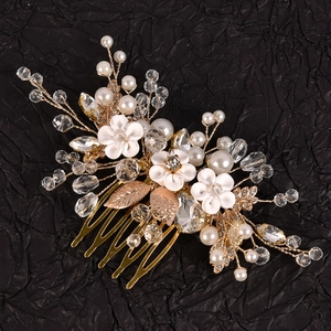 Peigne de mariée avec fleurs blanches, cristaux et feuilles dorées sur fond noir texturé