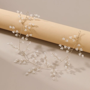 Détail d'un serre-tête de mariée fait main avec fil doré et perles de cristal brillantes