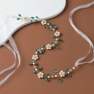 Detail of handmade bridal belt with pearls, crystals and emerald green rhinestones