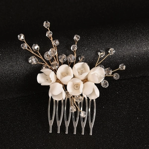 Elegant bridal hair comb featuring handmade white resin flowers and crystal beads on gold wire