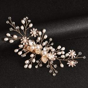 Detail of handcrafted bridal hair pin with golden alloy flowers, pearls and crystals