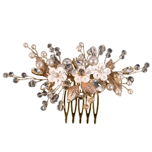 Détail d'un peigne de mariée avec fleurs en résine blanche, perles, cristaux et feuilles