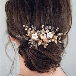 Détail du peigne de mariée avec fleurs en argile blanche et perles de cristal sur chignon bas