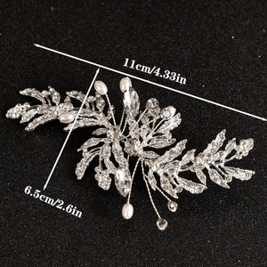 Silver leaf bridal brooch with rhinestones and white pearls on black background