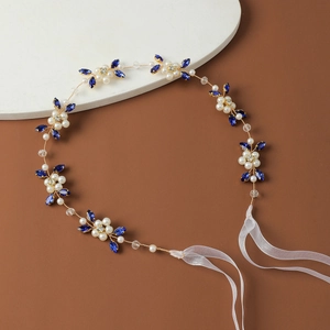 Detailed close-up of handmade bridal belt with blue rhinestones and white pearls