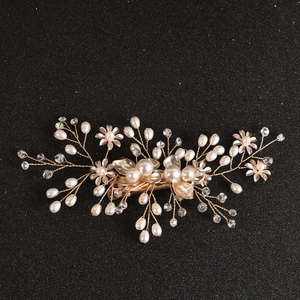 Detailed macro shot of bridal hair clip with gold wire pearls and crystal flowers