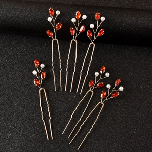Macro detail of 5 emerald-style U-shaped hairpins with red crystals and pearls