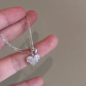 Detailed close-up of double heart pendant bracelet featuring sparkling zircon stones