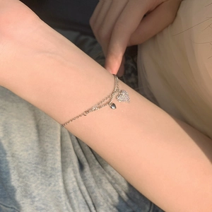 Elegant double-layered silver heart bracelet with cubic zirconia on a female wrist