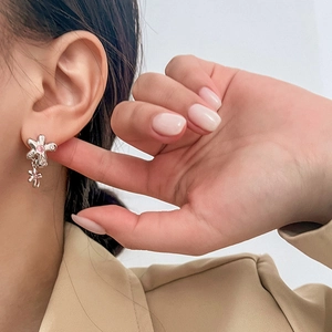 Boucles d'oreilles pendantes doubles fleurs en argent avec cristaux roses portées par mannequin