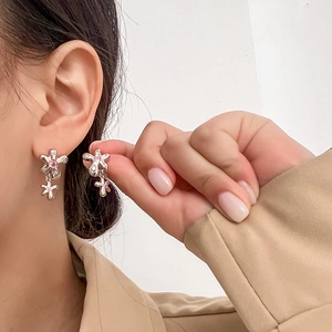 Boucles d'oreilles fleur argentée avec pierre rose portées pour un style élégant