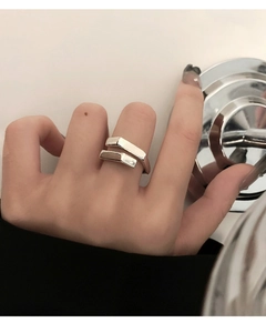 Close-up of a minimalist silver geometric open ring with rectangular double-layered design