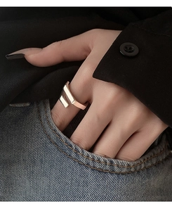 Minimalist silver geometric open ring shown worn against a dark shirt and denim pocket