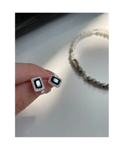 Gros plan sur les boucles d'oreilles en zircon noir avec cristaux blancs pavés